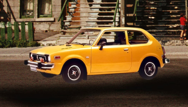 Une Honda 1969 originale jaune stationnée devant des maisons en rangée.