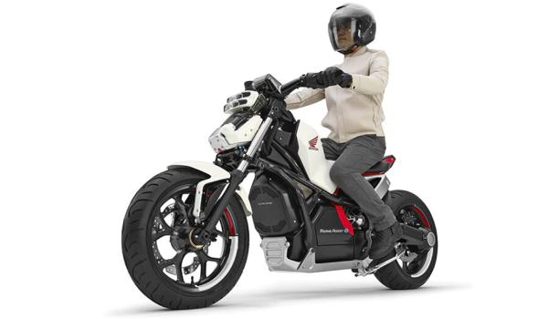 Une personne chevauche une motocyclette possédant le système d’assistance à la conduite de Honda dans un espace blanc.