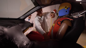 A close-up image of a crash test dummy at the beginning of a video is show.