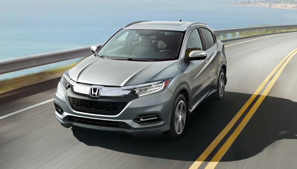 L’avant d’un VUS Honda roulant sur l’autoroute avec un plan d’eau d’un côté.